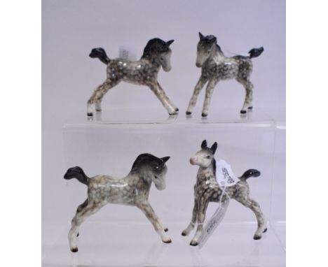 A Beswick Foal, small, gambolling left, 996, another, small, stretched upright, 3rd version, 763 (leg glued), and two others,