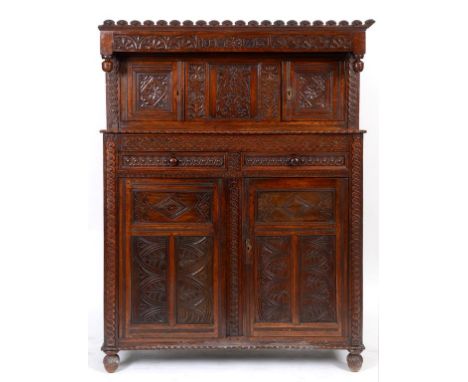An oak court cupboard, initialled IBM and dated 1760, with carved decoration, having a pair of panel doors above two drawers,