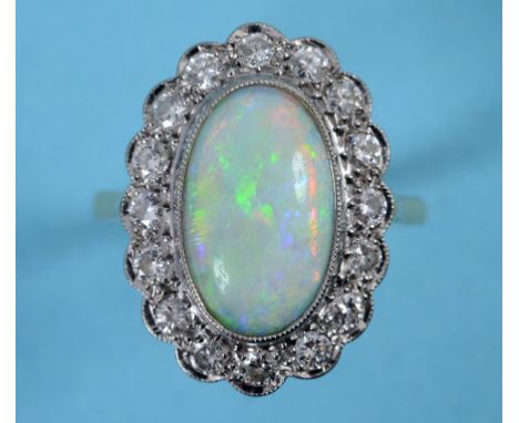 A gold ring, the central oval opal within a surround of 18 diamonds, approx. ring size Q½  See inside back cover colour illus
