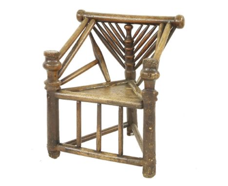 An elm and ash Warwick armchair,17th century, with bold turned supports and a triangular solid seat, with applied metal repai