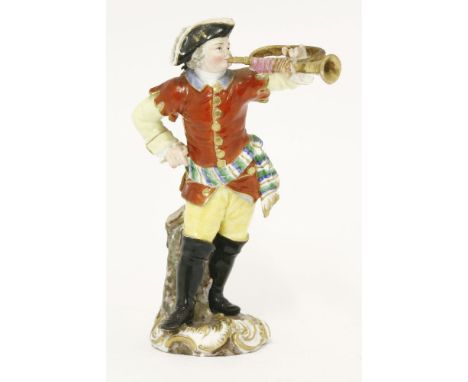 A Meissen Figure of a trumpeter, his right hand resting on his hip, wearing a red jacket and yellow breeches tied in the midd