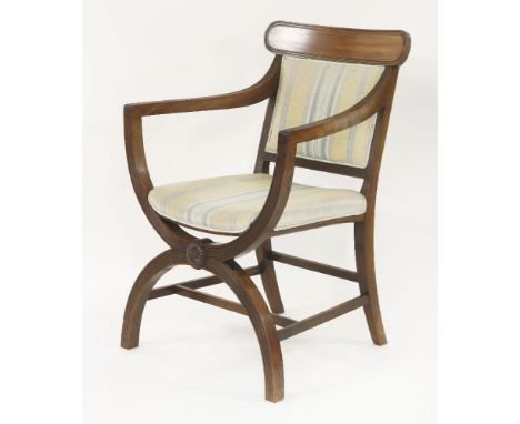 A Regency style mahogany 'X' frame reeded open armchair,  the back rail carved with a boss, the seat and back in green stripe