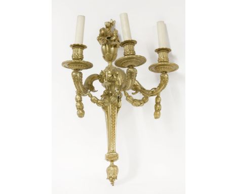 An ormolu wall light,   the three scrolled branches draped with swags of husks on a backplate surmounted with an urn and flow