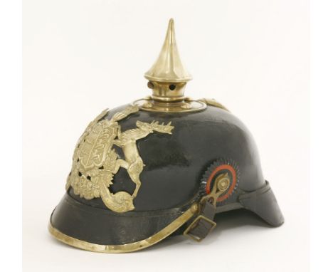 An Imperial German Württemberg Pickelhaube,the black leather helmet with a gilt brass plate and spike, with original ear rose