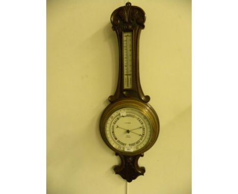 A CARVED WALNUT ANEROID BAROMETER WITH THERMOMETER, THE EARTHENWARE REGISTER INSCRIBED J D FISHER HIGH STREET LINCOLN