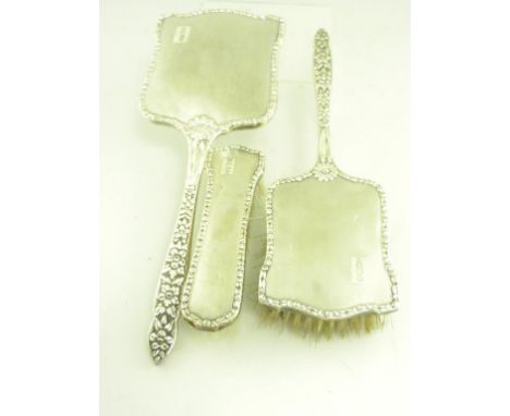 AN ELIZABETH II SILVER THREE PIECE BRUSH SET, ENGINE TURNED IN EMBOSSED BORDERS, BIRMINGHAM 1959