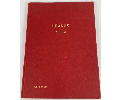 A vintage red Uranus stamp album of assorted world stamps. 