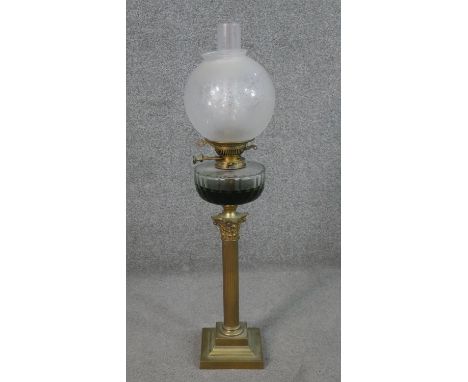 A Victorian brass Corinthian column design oil lamp with faceted glass oil well and etched frosted glass globe shade. H.79 W.