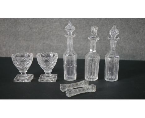 A collection of 19th century cut crystal, including a pair of salts with lemon squeezer bases, a pair of knife rests and thre