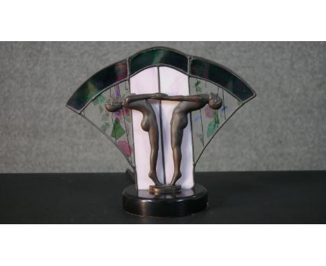 An Art Deco lead stained glass fan table lamp with two spelter dancers holding hands. H.27 W.31 D.14cm 