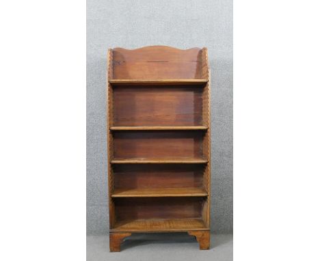 A George III pine waterfall style bookcase, with a shaped top, over four adjustable shelves, on shaped bracket feet. H.166 W.