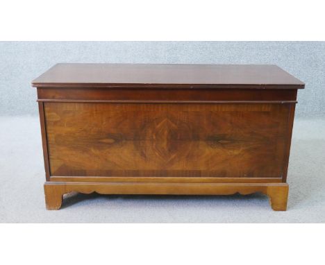 A 20th century Georgian style walnut coffer, with a rising lid, the front crossbanded and quarter veneered, on bracket feet. 