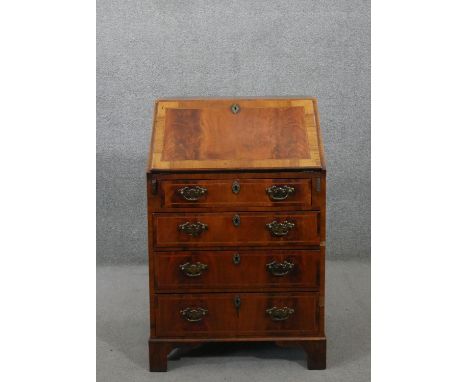An 18th century style figured walnut bureau, of narrow proportions, with a crossbanded fall front enclosing a fitted interior