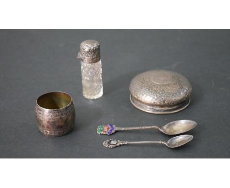 A collection of silver, including a silver topped cut glass perfume bottle, a silver napkin ring, two enamel souvenir spoons 