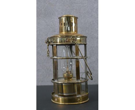 A vintage nautical design brass oil lamp with glass funnel and carrying handle. H.36 Dia. 16cm. 