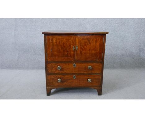 A 19th century mahogany night cabinet, with two cupboard doors over two long drawers, on shaped bracket feet. H.73 W.68 D.45c