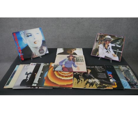 A collection of approximately fifteen vintage vinyl records, including Wings, Band on The Run, Stevie Wonder, Simon and Garfu