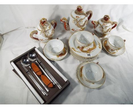 A Japanese tea set depicting a geisha girl on the cups and a Japanese chopstick set