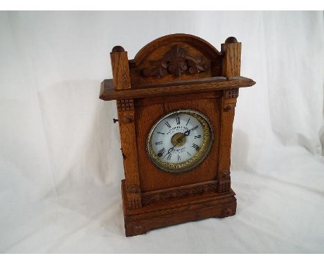 An oak cased mantel clock with integral alarm, the white dial marked Fattorini & Sons, Bradford, Patent Automatic Alarm, Pate