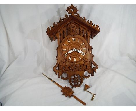 A good example of a Gothic carved bahnhausle style cuckoo clock, wood plate double fusee movement, complete with matching car