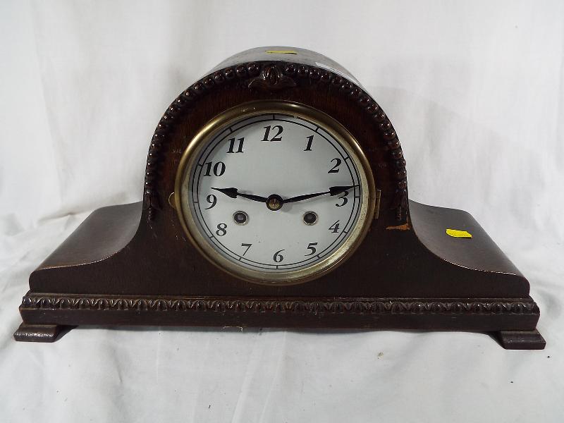 A carved mantel clock with pendulum and H & B movement D.R.G.M No. 916380