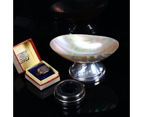 A mother-of-pearl table salt on silver stand, a silver napkin ring, and a silver signet ring (3) 