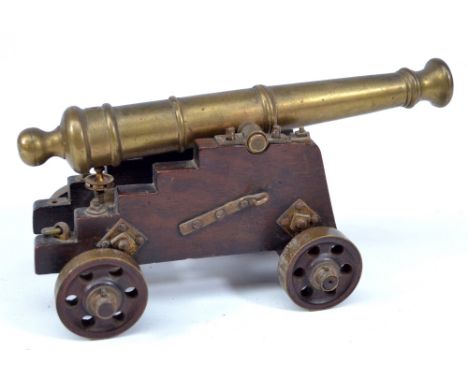 An early 19th century brass model signal cannon on wooden base, the barrel inscribed 'Relic of Royal George, sunk 1782, raise