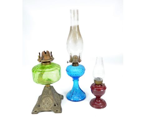 A late Victorian metal based oil lamp decorated with anchors and with green glass reservoir, a moulded blue glass oil lamp an