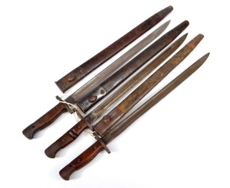 Three military issue wooden and steel handled bayonets, each with broad arrow and War Department stamps and with leather meta