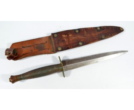 A Sykes Fairbairn type commando knife, with horizontal ring grip and shaped blade, in associated scabbard, length of blade 17