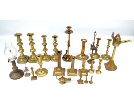 A collection of candlesticks from the late 18th century to later periods of varying form and size, predominantly brass, also 