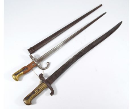 A late 19th century Chassepot bayonet, with brass grip, and a further French bayonet with metal scabbard and part wood and pa