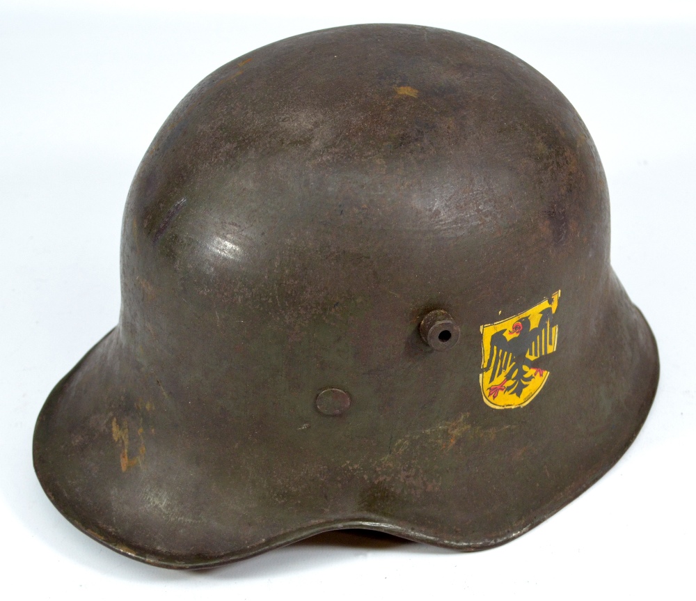 A German WWI helmet with applied black eagle decal to left side and ...