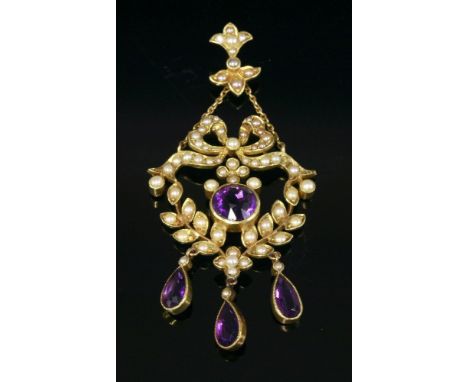 An Edwardian amethyst and split pearl pendant,with a bow top and laurel swags below.  All set with graduated split pearls, a 