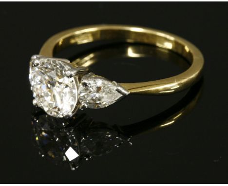 An 18ct gold single stone diamond ring,with pear cut diamond set shoulders.  A brilliant cut diamond with an estimated weight