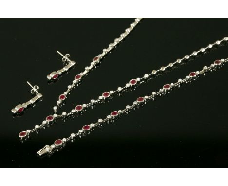 A Continental white gold, ruby and diamond suite,composed of a 'Y' necklace, line bracelet and a pair of earrings.  The neckl