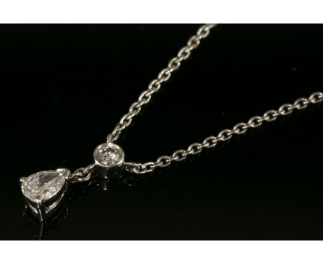 A platinum two stone diamond pendant,with a pear shaped diamond with a stated weight of 0.36ct, claw set and suspended below 