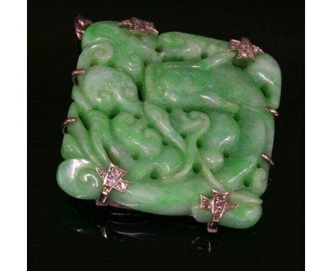 An Art Deco carved jade plaque brooch/pendant, c.1930,with diamond set claws.  The carved and pierced jade plaque depicting a
