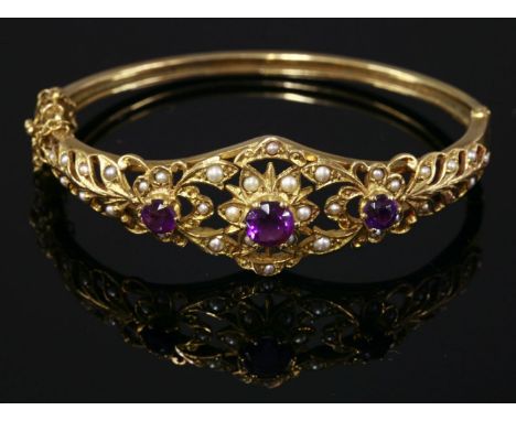 A 9ct gold, amethyst and split cultured pearl hinged bangle, London 1974.  The top half with three graduated star flower clus
