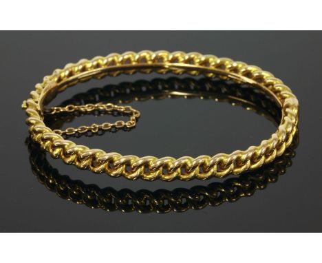 A cased late Victorian gold hinged bangle,of curb chain form, with a concealed box clasp and safety chain, marked 15C