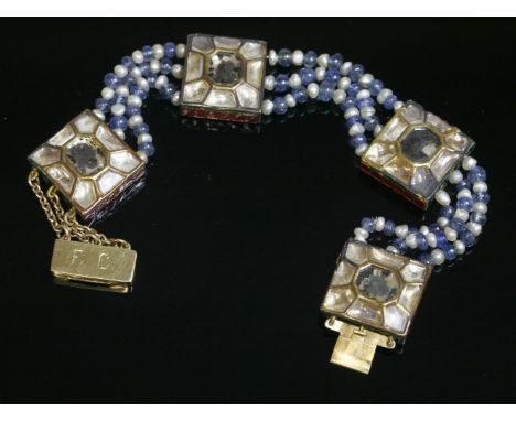 A cased Indian Jaipur enamel gold and gem set bracelet,with four polychrome enamelled gold plaques with lasque cut quartz, Ku