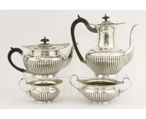 An Edwardian silver four-piece tea and coffee service,by Walker and Hall, Sheffield 1900,of half fluted compressed circular f