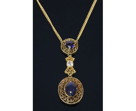 A Continental sapphire, diamond and gold Edna May pendant, c.1930,a circular mixed cut sapphire, claw set to a pierced scroll