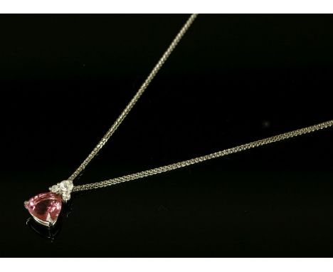 An 18ct white gold pink tourmaline and diamond pendant,with a trilliant shaped pink tourmaline, three claw set to a wire coll