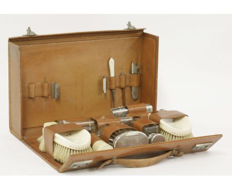 A gentlemen's travelling dressing table set,in a fitted leather case,stamped Asprey, London,containing:four silver-mounted gl