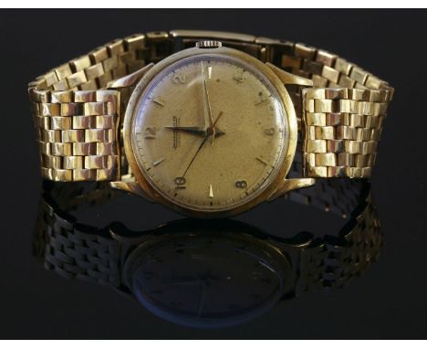 A gentlemen's 9ct gold Jaeger-LeCoultre mechanical watch,on a later 9ct gold brick link bracelet.  Circular silvered dial wit