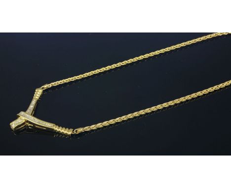A Continental gold and diamond set necklace,with a 'V' shaped crossover centrepiece, channel set with graduated baguette and 