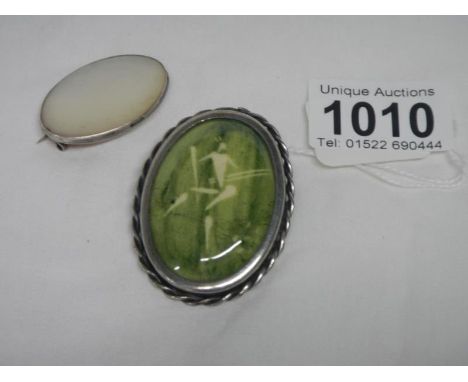A silver mother of pearl brooch and a green stone brooch