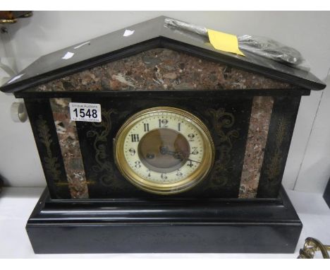 A black slate mantel clock with marble inlay
