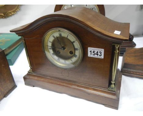 An oak mantel clock with brass pillars